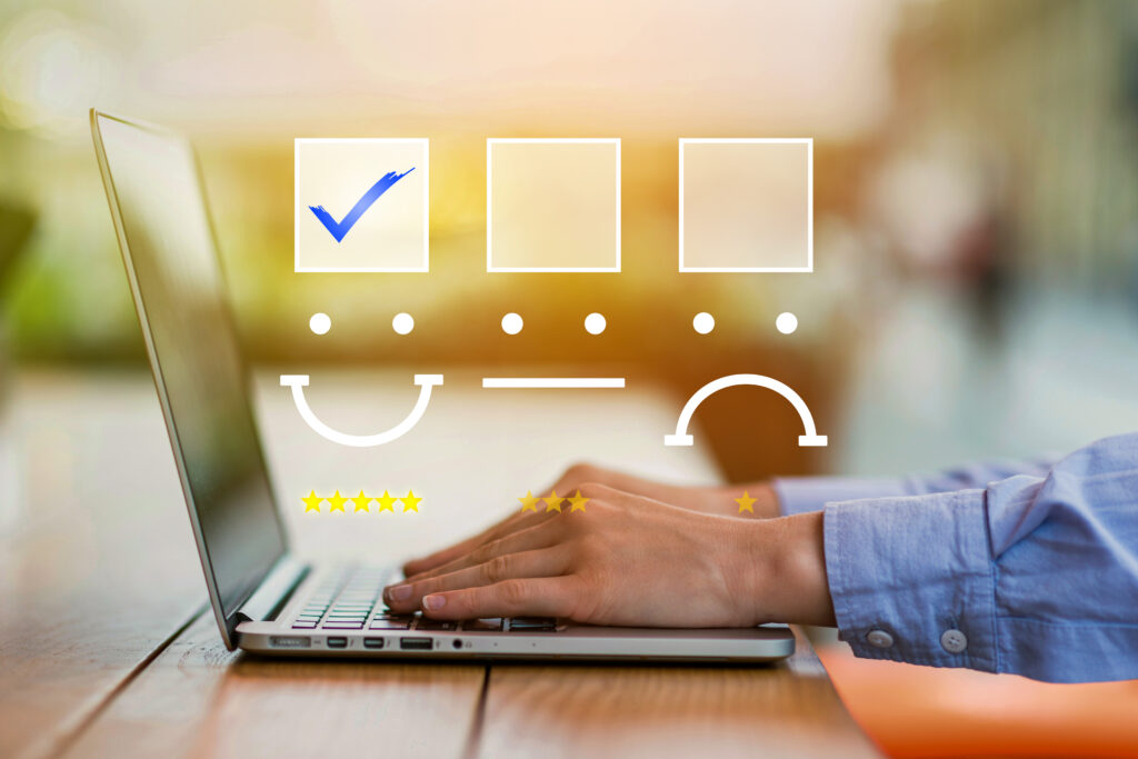 Mains tapant sur un clavier d'ordinateur portable avec des icônes de satisfaction client