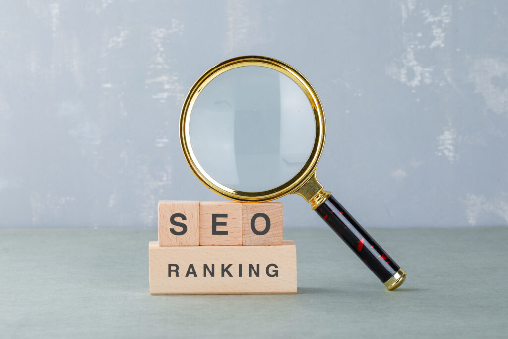 Loupe posée sur des blocs de bois avec les mots SEO et Ranking